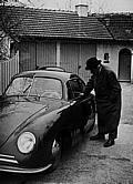 1950, Ferdinand Porsche neben dem 356 Gmünd-Coupé, am Steuer sein Sohn Ferry Porsche. Im Hintergrund ist die Doppelgarage der Porsche-Villa in Stuttgart zu sehen, in der die ersten Volkswagen-Prototypen gebaut wurden.